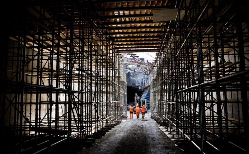 Arbetare på väg ut ur en tunnel under konstruktion.